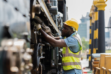 Locomotive repair garage, Mechanic, Engine Mechanic. Black people. African American engineer checking, repairing, maintaining locomotive engine. Railway engineer and train wheel in train garage