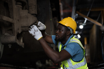 Locomotive repair garage, Mechanic, Engine Mechanic. Black people. African American engineer checking, repairing, maintaining locomotive engine. Railway engineer and train wheel in train garage