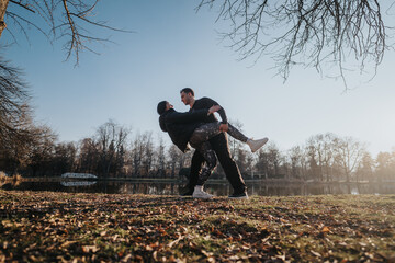A couple sharing a joyful moment outdoors in a serene park with trees, open space, and clear skies...