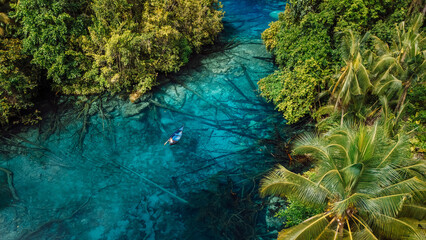 Boat in transparent lake with crystal blue water in Indonesia. Aerial view
