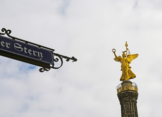 street sign pointing  Victoria statue on the top of the Victory Column, Berlin, Germany