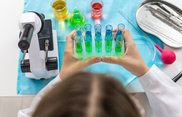 Laboratory research test tubes reagents and microscope. Selective focus.