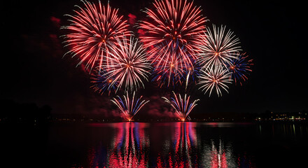 Colorful fireworks exploding in the night sky over the water  fireworks in honor of the  Independence Day 4th of July gif