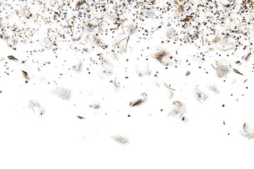 Scattered confetti and small paper pieces falling on a white surface creating a festive atmosphere