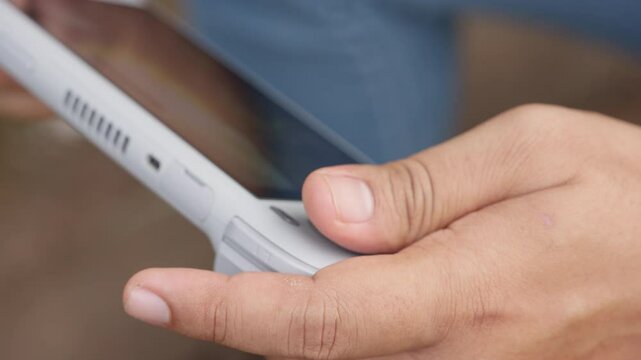 A person is holding a white game controller. The person is looking at the screen
