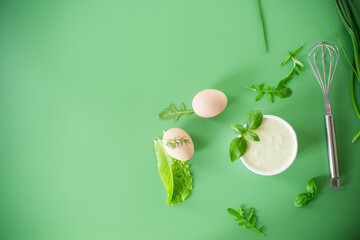 homemade egg mayonnaise with herbs in a bowl on a green background