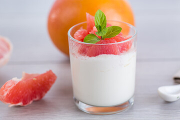 Natural fermented milk yogurt with citrus fruits on a wooden table