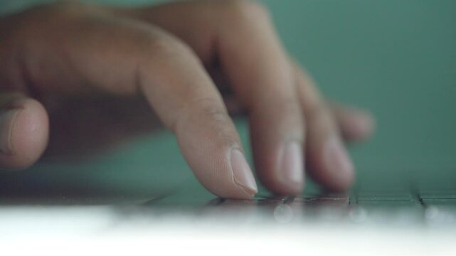 A person is typing on a laptop keyboard. The person is using the space bar. The person is using the shift key