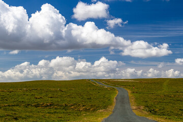 Minor rural road in landscape with dramatic sky