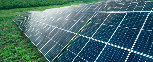 Aerial view of a solar farm generating solar energy.Solar panels park generating green energy electric.Green energy reduce carbon emissions and makes earth cleaner and more ecological.	
