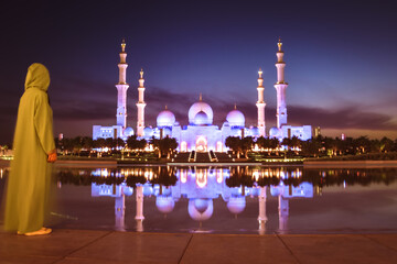 Close up Woman in traditional Arabic dress Abaya in Wahat Al Karama or Oasis of Dignity near Sheikh Zayed Grand Mosque in Abu Dhabi, showcasing cultural elegance,iconic Islamic architecture at sunset