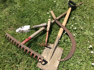 Garden tools lying on a surface of green grass.