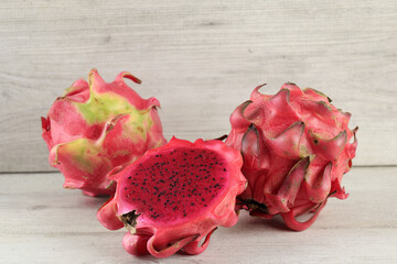 Halved Red ​​Dragon Fruit or Buah Naga Merah on White Table