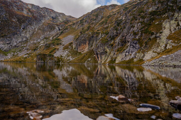 Close-Up of Kidney Lake's Rocky Shoreline Reflecting Steep Cliffs in the Seven Rila Lakes, Rila Mountains, Bulgaria