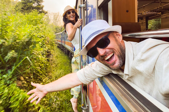 Happy excited passenger travel couple stand by doorstep enjoy popular train ride journey Kandy to Ella and admire Sri lanka lush jungle landscapes. Embrace freedom, curiosity, wonder asia travel