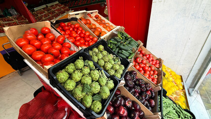 Vibrant market display of lush artichokes and tomatoes, celebrating Italian Green Week and quirky Vegetable Appreciation Day