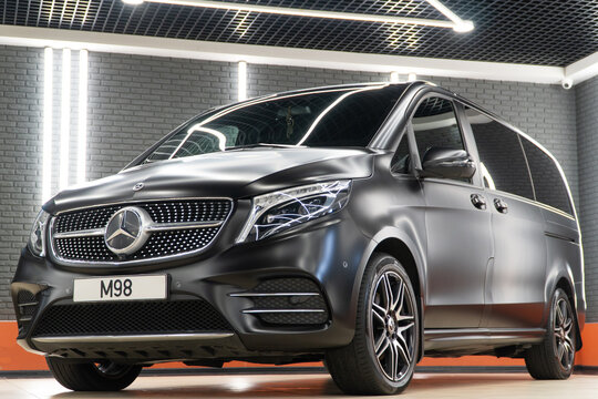 Black matte Mercedes-Benz V 300 d luxury MPV in the showroom after wrapping in matte satin and after detailing. Car wrapping, tuning, styling. Germany car. 