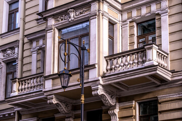 An antique lantern on a pole against the background of a house wall.