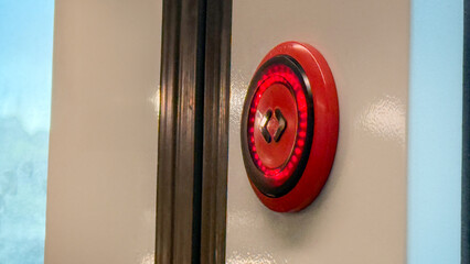 Red emergency button, a sentinel of safety vigilance, juxtaposes technological superstition, echoes...
