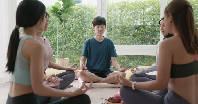 Group of young adult gen z asia people mindful floor sitting circle zen class stress relief self love at studio relax life center. Happy diverse asian LGBT gay deep serene mental health care workshop.