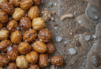Obraz premium Salty macadamia nuts scattered on textured surface create delightful snack experience