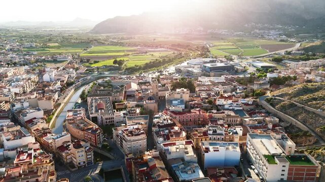 Drone point of view ancient spanish city of Orihuela, aerial shot of architecture and Segura River canal during sunny summer day. Costa Blanca, Alicante province. Spain