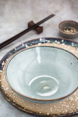 Empty rustic ceramic bowl and chopsticks, asian style table setting, space for text