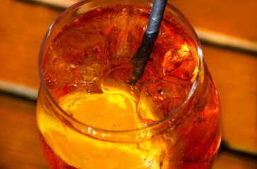 A close-up of a vibrant orange Aperol Spritz in a condensation-covered glass.