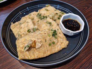 Serving Fried Tempeh (Tempe mendoan) with Soy Sauce Dip on a Plate