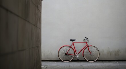 Naklejka premium Minimalist bicycle parked against a concrete wall in an urban alley