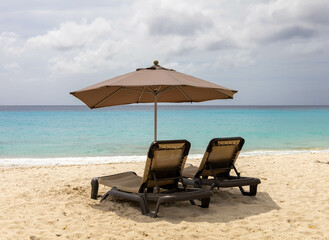 Two sun loungers and a parasol on the beach of Kleine Knip, Curaçao.