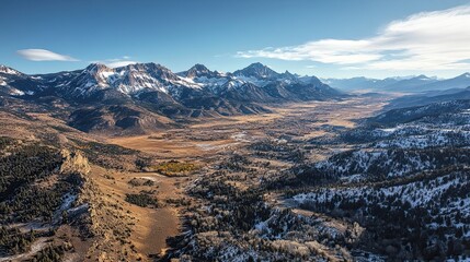 Witnessing Majesty Snow Kissed Peaks Embrace a Golden Valley Below bathed in Autumn Hues with a serene blue sky over the