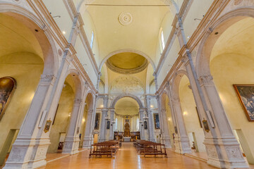 Ferrara, Italy - May 17, 2025: Sunlight illuminating the polished floor of the nave in Saint Christopher church of Charterhouse of Ferrara, highlighting wooden benches and grand columns
