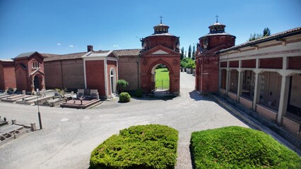 Ferrara, Italy - May 17, 2025: Wide angle view of the entrance to the Ferrara Charterhouse, showing the terracotta arch, decorations, and the hallway with arches and domes, in Ferrara, Italy