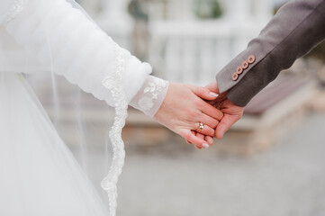 A tender moment captured during a wedding ceremony showcasing a bride and groom holding hands with...