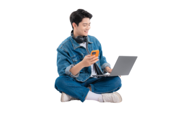 Full body image of Asian guy using laptop and phone on png background	