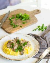 Creamy mushroom sauce over mashed potatoes garnished with parsley on rustic table setting