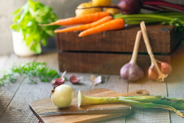 Fresh vegetables and herbs on wooden cutting board in rustic kitchen setting