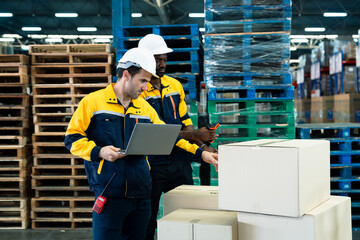 Logistics warehouse team of african adult male and caucasian adult male checking and scanning barcode on box using scanner and laptop for shipment preparation in industrial warehouse zone