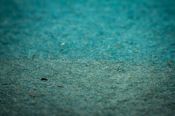 Extreme closeup of turquoise handmade paper with shallow depth of field.
