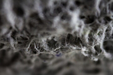 Extreme close up of old gray handmade paper clay with a structure and rough texture. Paper recycling. Selective soft focus, shallow depth of field.