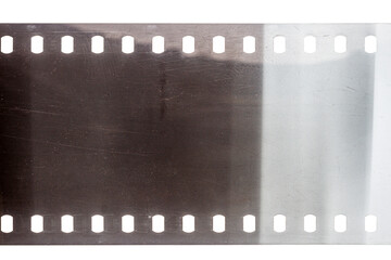 Dusty and grungy 35mm film texture or surface. Perforated scratched camera film isolated on white...