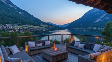 Obraz premium Elevated view of rustic chalet with glowing lights and large wooden deck facing alpine lake and peaks