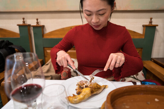 Asian tourist enjoying Segovia culinary delight