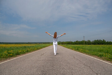 Back view of woman running on country road
