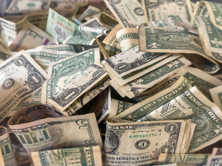 Closeup of U.S. and other currency in a transparent donation box near the main entrance to a botanical garden, for concepts of donation and anonymous financial support