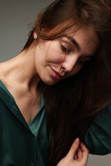 Fototapeta premium Capturing a moment of serenity as a woman gently brushes her hair in soft natural light