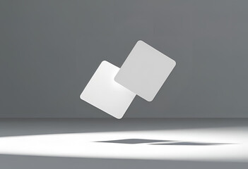 
White rectangular cards float in a minimalist gray space, spotlighted below, perfect for mockups and presentations.