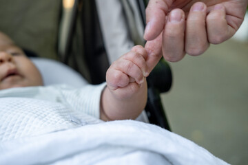 The gentle touch of a mother hand with her newborn baby. Fingers confidently holding the mother finger, as if this is the most important and safest place in the world.