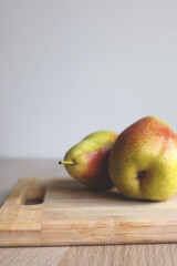 Vertical Composition of Juicy Pears on Wooden Cutting Board